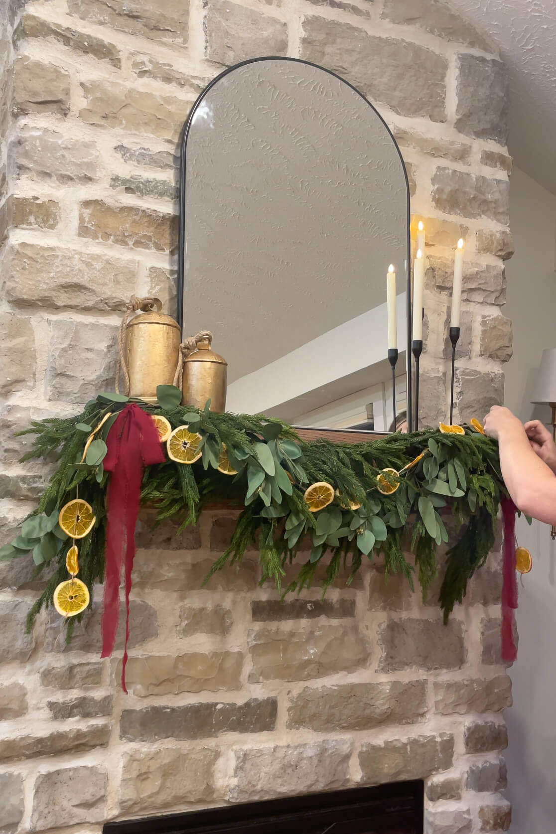 Adding candlesticks and red ribbon to my fireplace Christmas decor. 